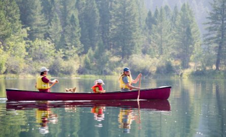 Family with their dog in canoe on lake